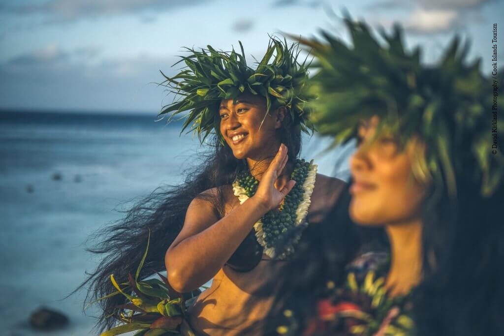 Tänzerinnen mit Haarkranz auf den Cook Inseln im Südpazifik mit dem Meer im Hintergrund