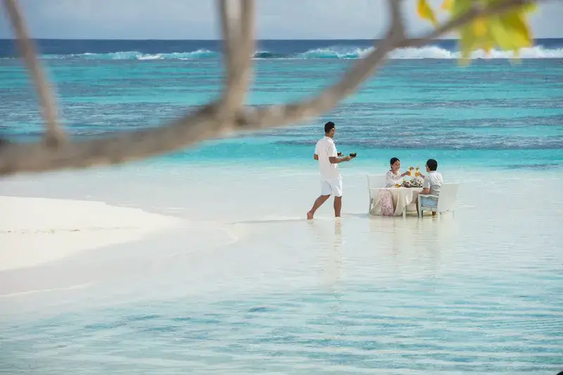 Lagunenfrühstück in Französisch Polynesien mit dem Tisch im Meer nahe dem Strand.