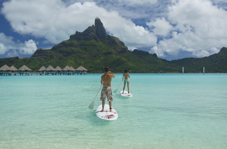 Stand Up Paddling in der türkisblauen Lagune von Bora Bora beim Inselhüpfen in Polynesien