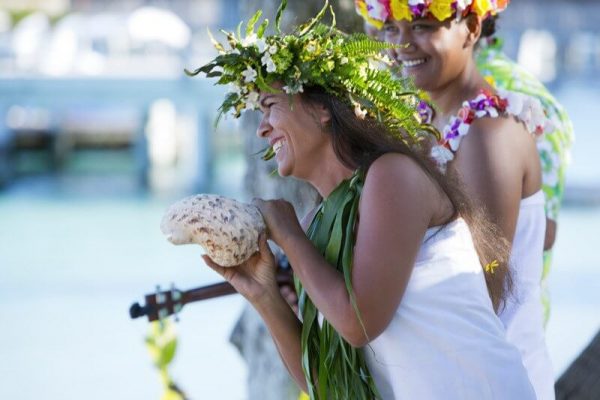 polynesische Frauen mit Haarkranz beim Tanzen und Singen traditioneller Lieder